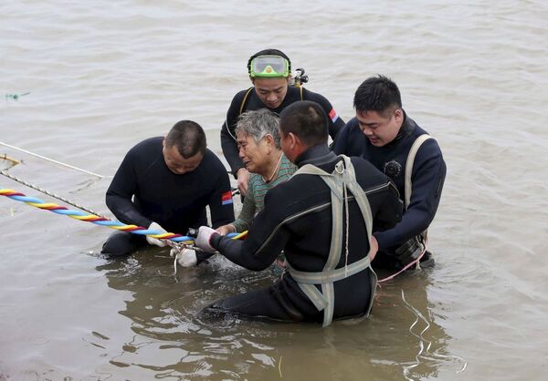 امدادگران در حال کمک به یک زن پس از واژگون شدن کشتی در چین - اسپوتنیک ایران  