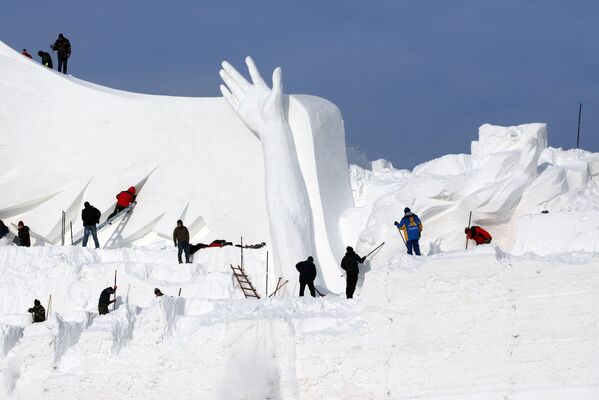 مردم در حال ساخت مجمسه ی برفی برای نمایشگاهHarbin Sun Island International Snow Sculpture Art Expo در شهر هربین چین - اسپوتنیک ایران  