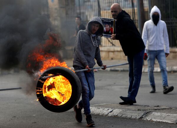 فلسطینی با لاستیک آتش زده در درگیری با نظامیان اسرائیلی - اسپوتنیک ایران  