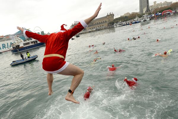 شرکت کننده با لباس بابانوئل در شنای کریسمس در بارسلونای اسپانیا - اسپوتنیک ایران  