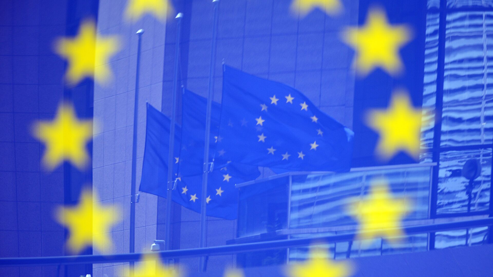 Флаги Евросоюза в отражении на стенде с эмблемой ЕС - اسپوتنیک ایران  , 1920, 19.01.2023