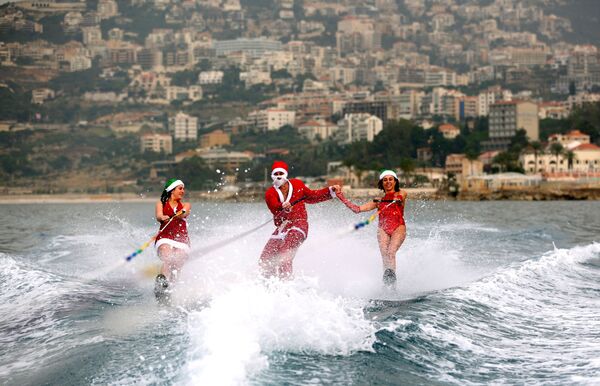 جوانان با لباس های بابانوئل مشغول موج سواری در جزیره جونیا لبنان - اسپوتنیک ایران  
