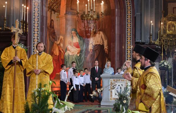 دیمیتری مدودف نخست وزیر روسیه به همراه همسرشان سوتلانا در مراسم تولد حضرت مسیح در کلیسای مسیح منجی، مسکو - اسپوتنیک ایران  