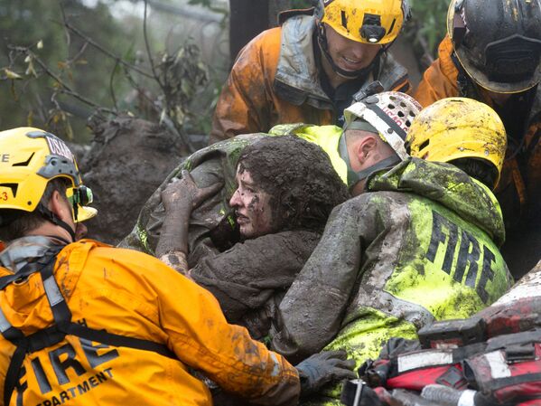 تیم امداد و نجات در حال خارج کردن یک زن از زیر آوار پس از رانش زمین درکالیفرنیا - اسپوتنیک ایران  