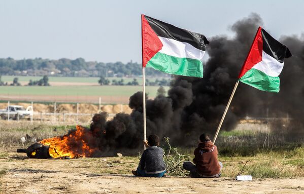 تظاهرکنندگان فلسطینی با پرچم این کشور در مرز بین اسرائیل و نوار غزه - اسپوتنیک ایران  