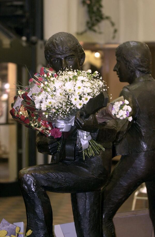 گل در دست مجسمه جورج هریسون در نزدیکی باشگاهی در لیورپول انگلستان - اسپوتنیک ایران  