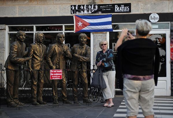 جهانگردان از مجسمه بیتلز در نزدیکی باری در کوبا عکس می گیرند - اسپوتنیک ایران  