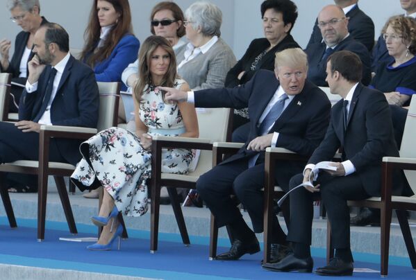 دونالد ترامپ رئیس جمهور آمریکا به همراه همسرش ملانیا در کنار امانوئل ماکرون رئیس جمهور فرانسه در حال تماشای رژه نظامی در خیابان شانزلیزه پاریس - اسپوتنیک ایران  