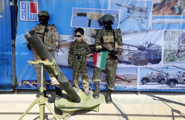 پسربچه ای در حال عکس گرفتن با سربازان در زمان برگزاری جشن 39-مین سالگرد انقلاب اسلامی در ایران - اسپوتنیک ایران  
