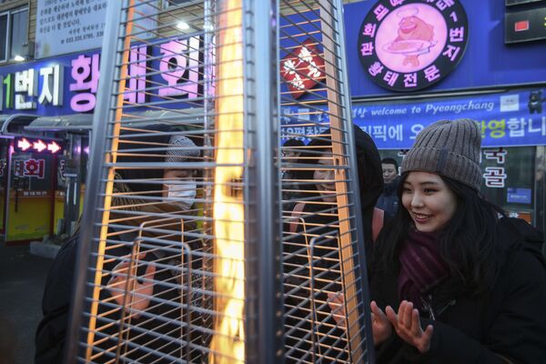 تماشاچیان در حال گرم شدن در استادیوم بازی های المپیک زمستانی پیونگ چانگ کره جنوبی - اسپوتنیک ایران  