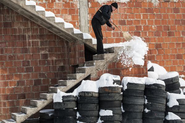 مردی در حال برف روبی در صربستان - اسپوتنیک ایران  