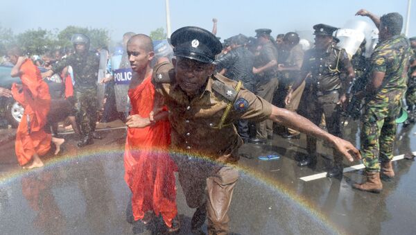 Полицейский уводит монаха с акции протеста в порту Хамбантота, Шри-Ланка - اسپوتنیک ایران  