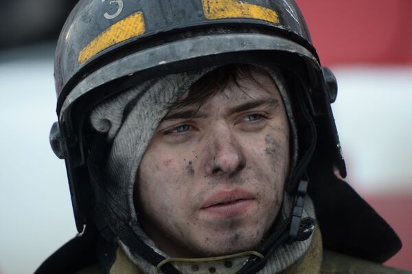 مأمور آتش نشانی هنگام اطفای حریق در مرکز تجاری-تفریحی « آلبالوی زمستانی» در کمروو روسیه - اسپوتنیک ایران  