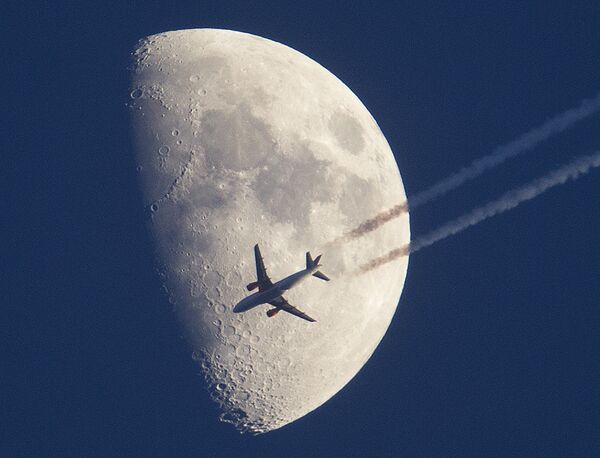 هواپیما در حال پرواز با زمینه ای از تصویر ماه در فرانکفورت آلمان - اسپوتنیک ایران  