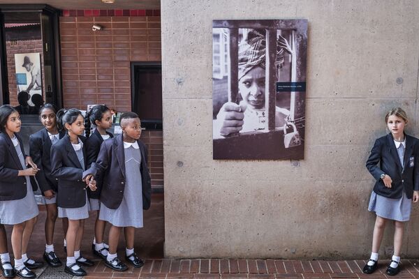 دانش آموزان مدرسه ای در آفریقای جنوبی با پرچمی که تصویر وینی نلسون ماندلا روی آن ترسیم شده است - اسپوتنیک ایران  