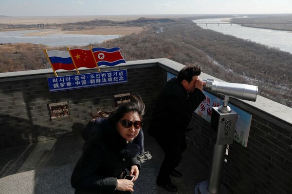گردشگران در مرز کره شمالی و چین خاک کره شمالی را تماشا می کنند - اسپوتنیک ایران  