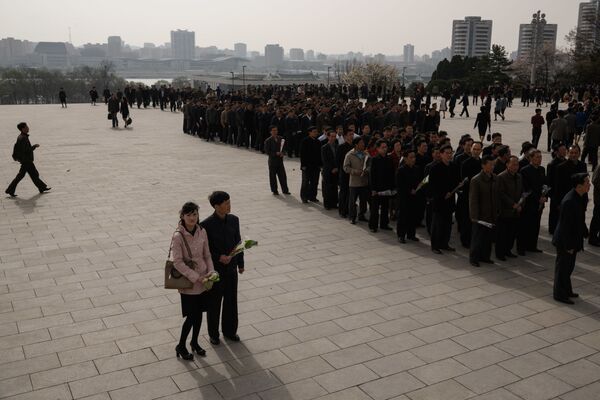 نثار گل به پای مجسمه رهبر کره شمالی در پیونگ یانگ در زمان جشن خورشید - اسپوتنیک ایران  