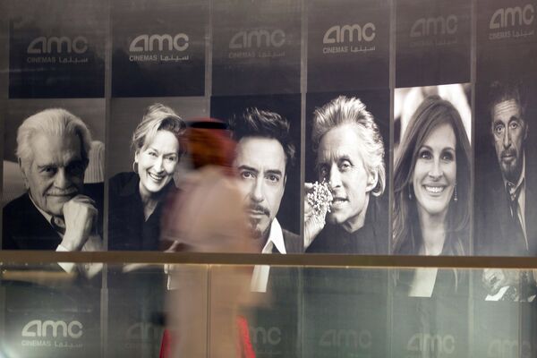 Посетитель проходит мимо плакатов с изображениями голливудских актеров в публичном кинотеатре в Эр-Рияде, Саудовская Аравия - اسپوتنیک ایران  