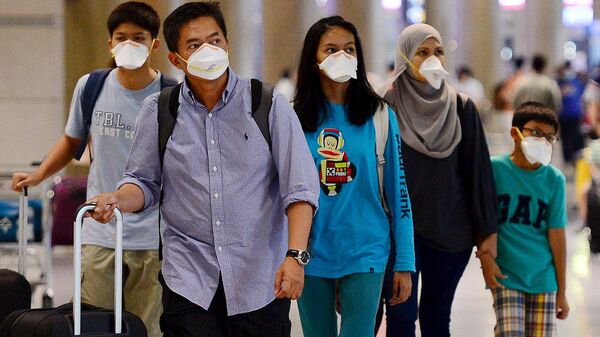 Туристы в защитных масках в международном аэропорте Сеула, Южная Корея - اسپوتنیک ایران  
