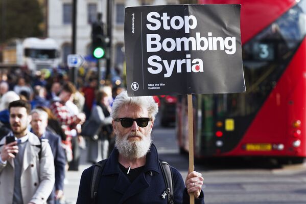 مردی با پلاکارد «سوریه را بمباران نکنید» در لندن - اسپوتنیک ایران  