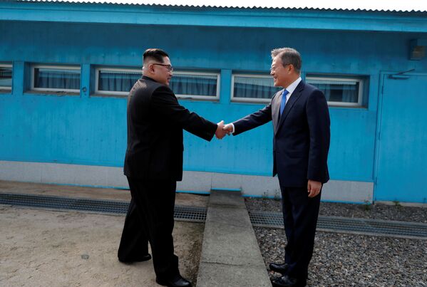 رهبران کره شمالی و جنوبی در زمان ملاقات دست های یکدیگر را می فشارند - اسپوتنیک ایران  