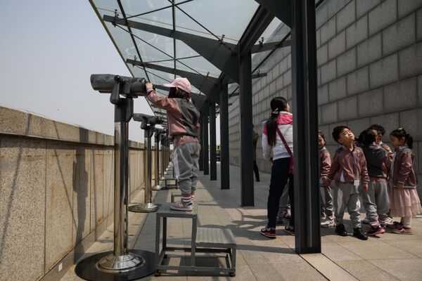 دانش آموزان مدرسه با دوربین به محل ملاقات رهبران دو کره نگاه می کنند - اسپوتنیک ایران  