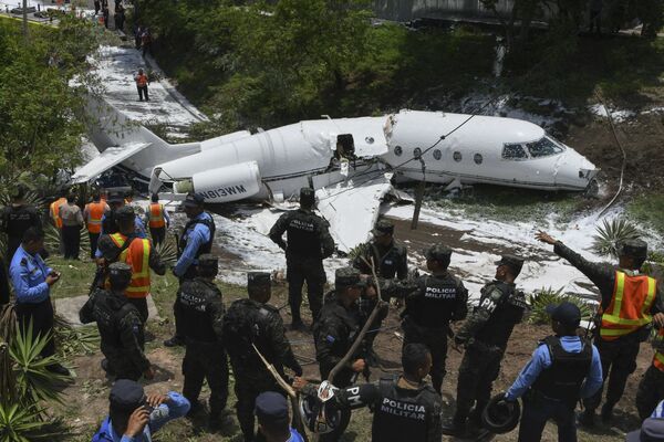 پلیس و نیروهای امداد در حین کمک رسانی پس از سقوط هواپیما در فرودگاه بین المللی پایتخت هندوراس که در حین فرود دچار سانحه شد - اسپوتنیک ایران  