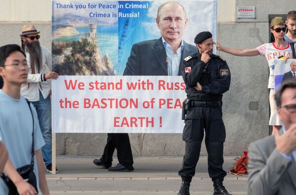 ساکنین اتریش  با تابلوهایی  از تصویر ولادیمیر پوتین ، در زمان ملاقات روسای جمهور اتریش و روسیه - اسپوتنیک ایران  