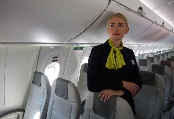 مهماندار در سالن هواپیمای Bombardier CS300 شرکت هواپیمایی airBaltic - اسپوتنیک ایران  