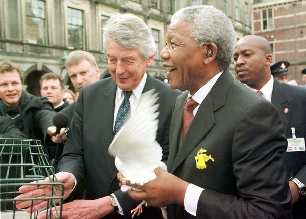 نلسون ماندلا رئیس جمهور آفریقای جنوبی و نخست وزیر هلند ویم کک ، کبوترهای سفید را در لاهه آزاد می کنند - اسپوتنیک ایران  