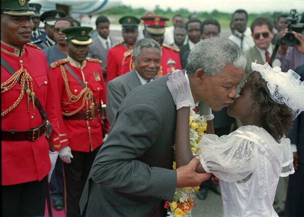 نلسون ماندلا رئیس جمهور آفریقای جنوبی در حال بوسیدن دختربچه در فرودگاه تانزانیا - اسپوتنیک ایران  
