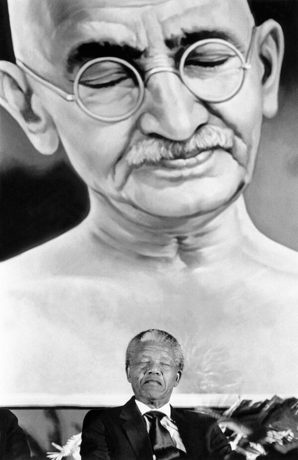 نلسون ماندلا رئیس جمهور آفریقای جنوبی زیر تصویر ماهاتما گاندی در سفرش به هند سال ۱۹۹۰ - اسپوتنیک ایران  