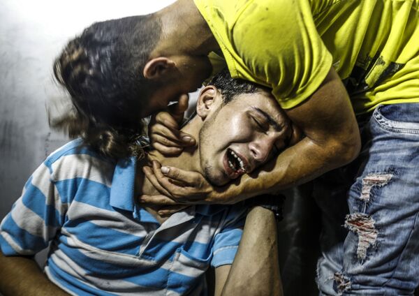 فلسطینی ها برای دو نوجوان که به طور اتفاقی در جریان حمله ی هوایی اسرائیل به نوار غزه کشته شده اند ، گریه می کنند - اسپوتنیک ایران  
