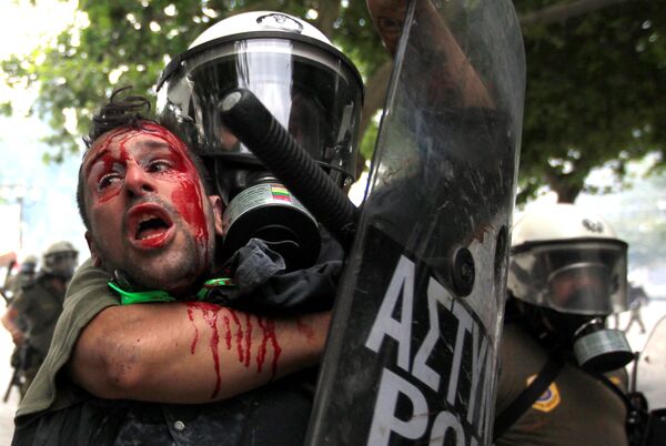 پلیس در حال دستگیری یکی از معترضین علیه اقتصاد دشوار در آتن، ژوئن سال ۲۰۱۱ - اسپوتنیک ایران  