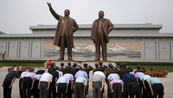 Поклонение перед бронзовыми статуями бывших лидеров КНДР Ким Ир Сена и Ким Чен Ира в ознаменование годовщины окончания японского колониального господства - اسپوتنیک ایران  