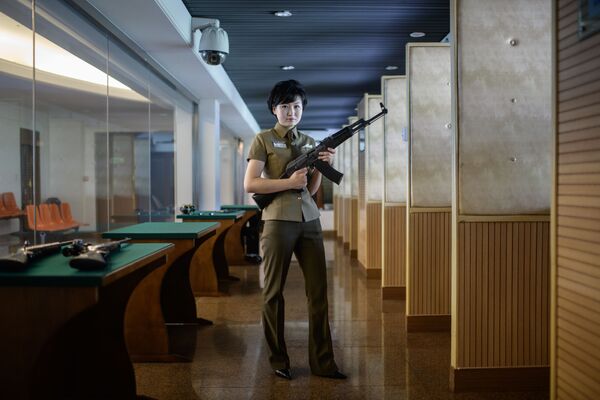 کیم جو یانگ 20 ساله که یک اسلحه ساخت کره شمالی را در سالن تیر اندازی در پیونگ یانگ در دست دارد. - اسپوتنیک ایران  