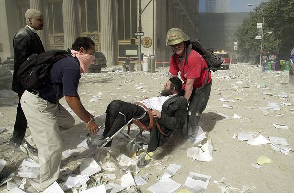 امدادگران، مردی را پس از سقوط  یکی از برج های مرکز تجارت جهانی نجات می دهند - اسپوتنیک ایران  