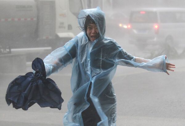 زنی زیر باران سیل آسا در چین - اسپوتنیک ایران  