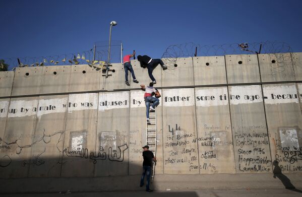 فلسطینی ها در حال صعود از دیوار - اسپوتنیک ایران  