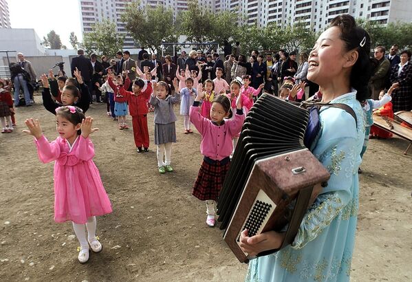کودکان کره شمالی در حال رقصیدن و آواز خواندن با معلم شان - اسپوتنیک ایران  