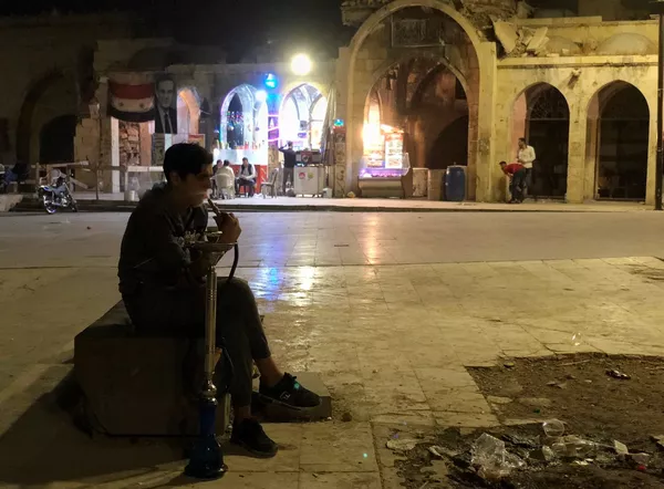 مردی در حال کشیدن قلیان در میدانی نزدیک بازار در حلب - اسپوتنیک ایران  