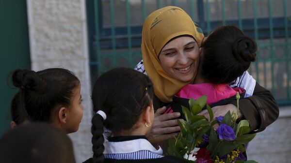 Palestinian teacher Hanan al-Hroub, who is shortlisted to win the Global Teacher Prize, is hugged by a student in the West Bank city of Ramallah February 17, 2016 - اسپوتنیک ایران  