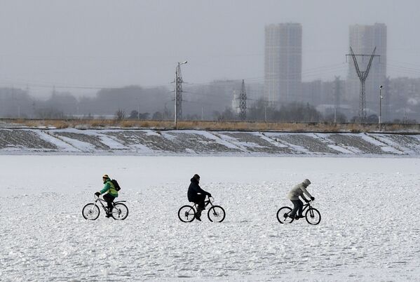 دوچرخه سواری مردم در روی آبگیر یخ بسته  واقع در مجاورت نیروگاه آبی نووسیبرسک روسیه - اسپوتنیک ایران  