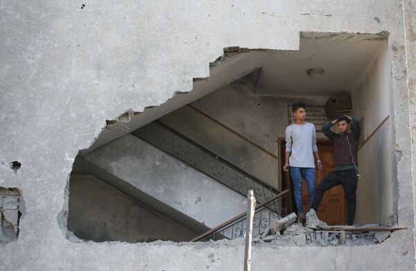 پسران جوان در یک خانه مسکونی آسیب دیده بر اثر حمله موشکی اسرائیل به نوار غزه - اسپوتنیک ایران  