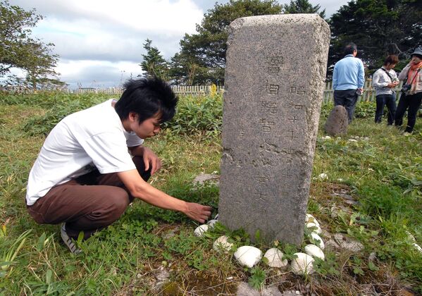نماینده هیات بدون ویزای ژاپنی در قبرستان قدیمی ژاپنی در جزیره کوناشیر - اسپوتنیک ایران  