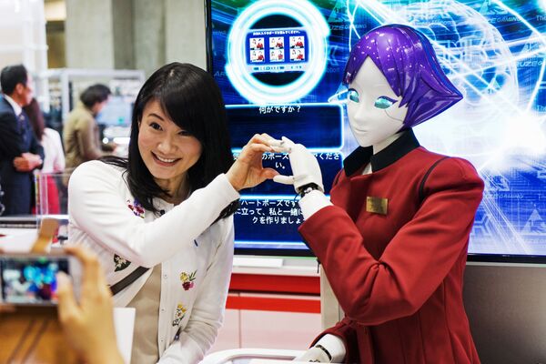 بازدید کننده نمایشگاه بین المللی ربات ها در توکیو به همراه ربات FASHION Junko Koshino - اسپوتنیک ایران  