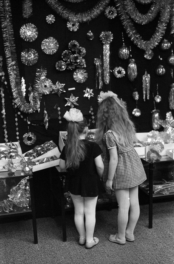 دو دختر بچه در حال تماشای وسائل تزئینی درخت کریسمس - سال 1973 - اسپوتنیک ایران  