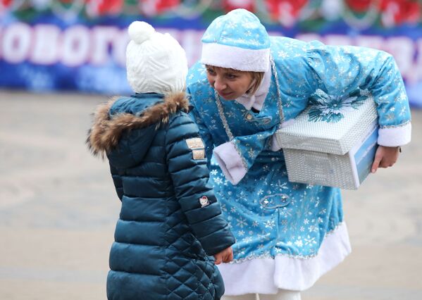 دختر برفی در حال دادن هدیه در زمان رژه بابا سرما و دختربرفی ها در کراسنودار - اسپوتنیک ایران  