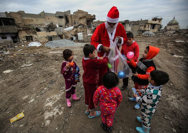 بابانوئل در حال دادن هدیه به بچه ها در موصل - اسپوتنیک ایران  