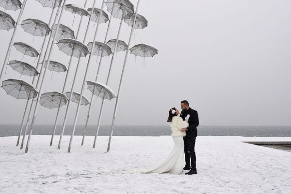 عروس و داماد در ساحل دریا هنگام بارش برف در یونان - اسپوتنیک ایران  